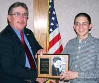 Matthew Mitchell, LaFollette, Tenn., accepts the 2005 Overall Judi Collinsworth Outstanding Junior Exhibitor Award from Holstein Association USA, Inc. Regional Representative Glenn Sageser.